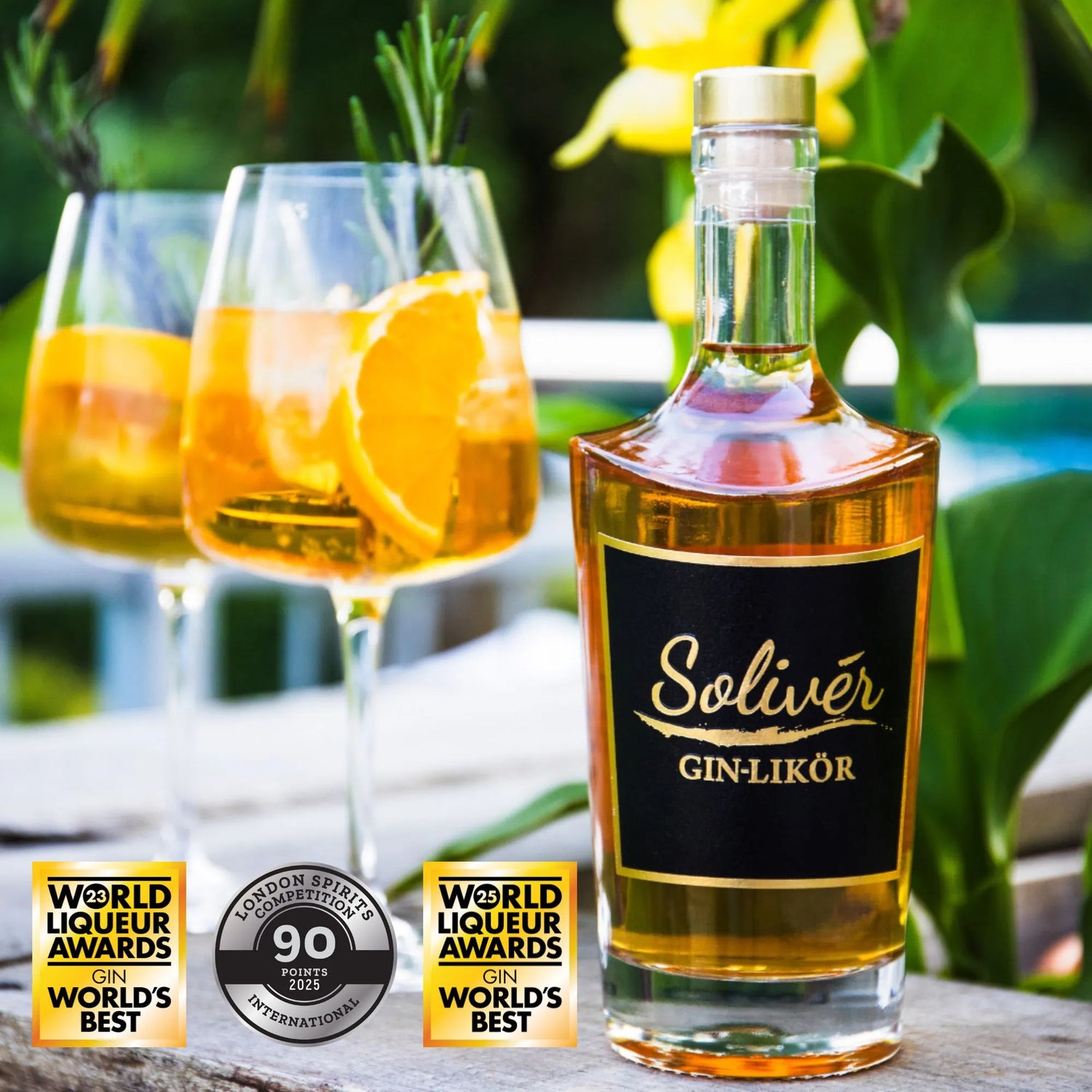 Flasche Solivér Goldapfel Gin-Likör auf einem Holztisch neben zwei Gläsern mit Orangen, Rosmarin und Eiswürfeln, dekoriert mit internationalen Auszeichnungen wie World Liqueur Awards und London Spirits Competion