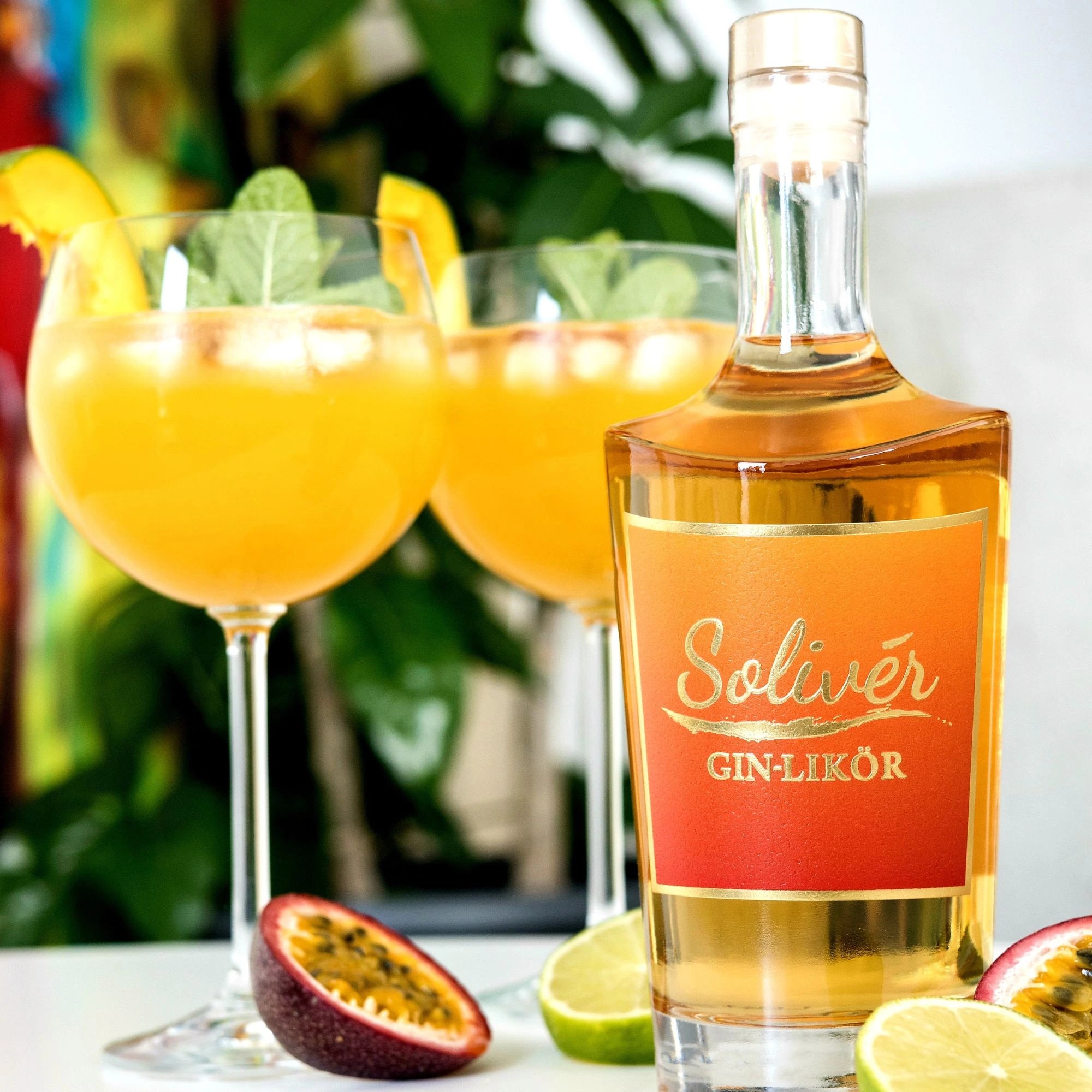 Solivér Mango-Maracuja Gin-Likör mit zwei Aperitifgläsern, frischer Minze, Maracuja und Limette – sommerlich und erfrischend.