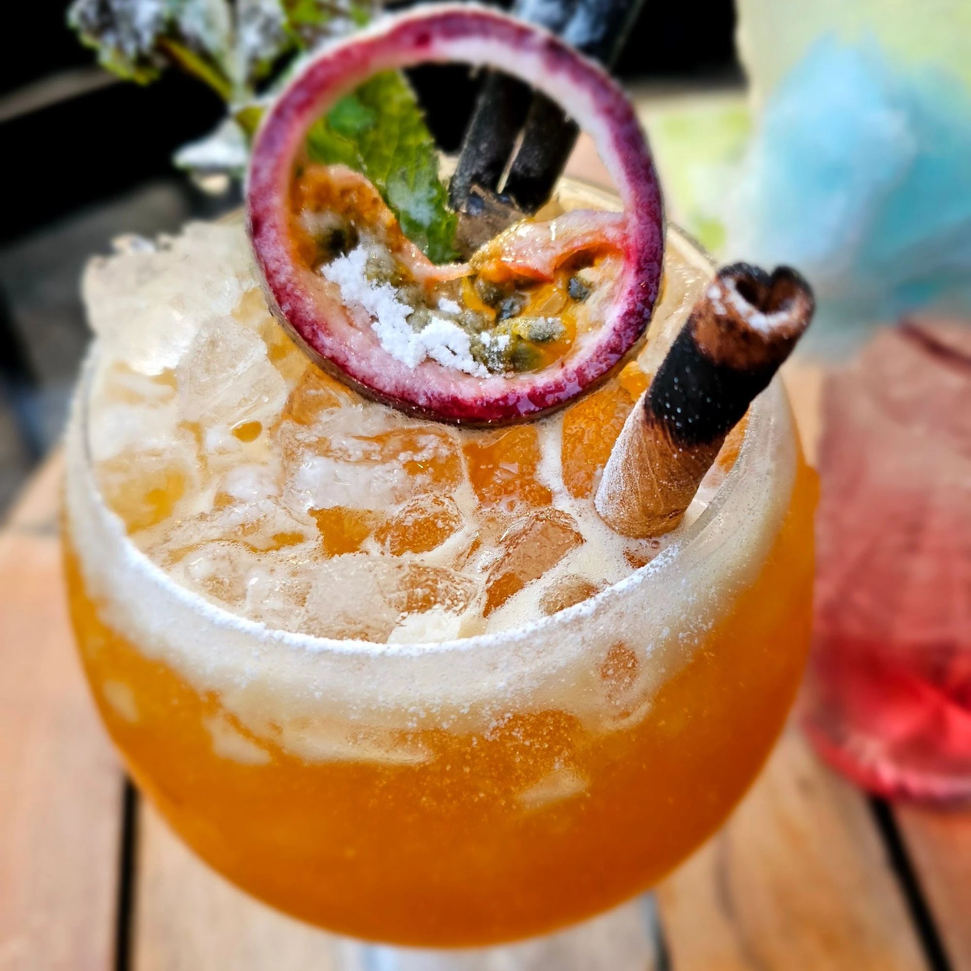 Exotischer Drink mit Crushed Ice, Passionsfrucht, Zimtstange und Minze – ein Sommerhighlight im Glas.