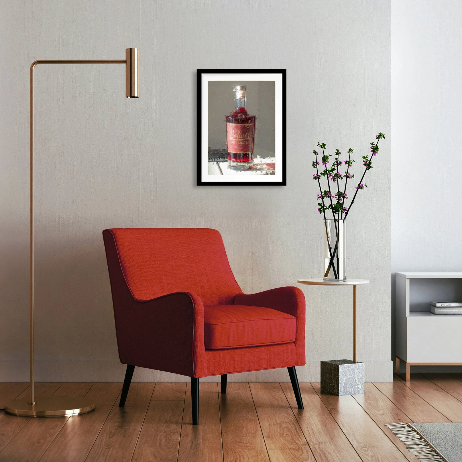Modern eingerichtetes Wohnzimmer mit rotem Sessel, goldener Stehlampe und kleinem Beistelltisch mit Vase, an der Wand hängt ein gerahmtes Bild einer Solivér Ginlikör Flasche mit rotem Etikett.